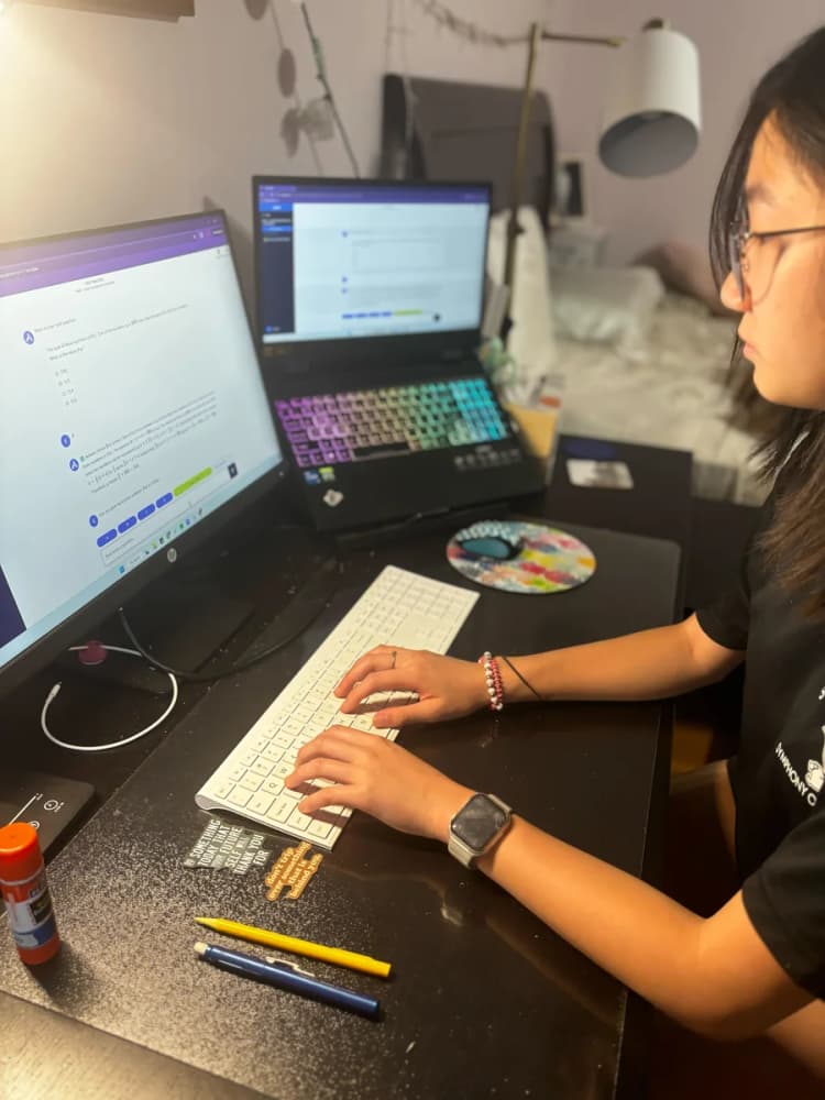 Student studying with Acely at a desk with two monitors
