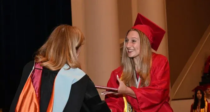 Graduation ceremony, student receiving diploma