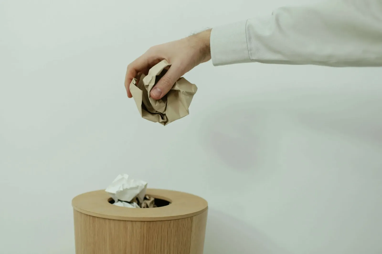 Person Putting Trash into Bucket