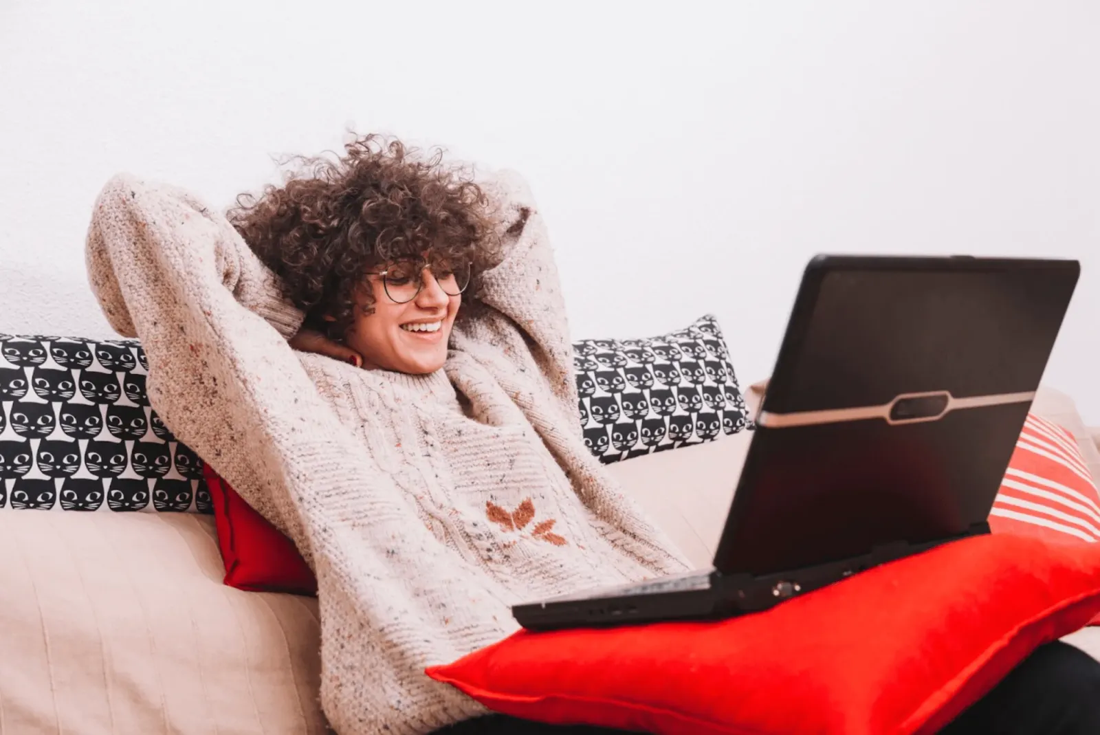 student laid back on couch with laptop